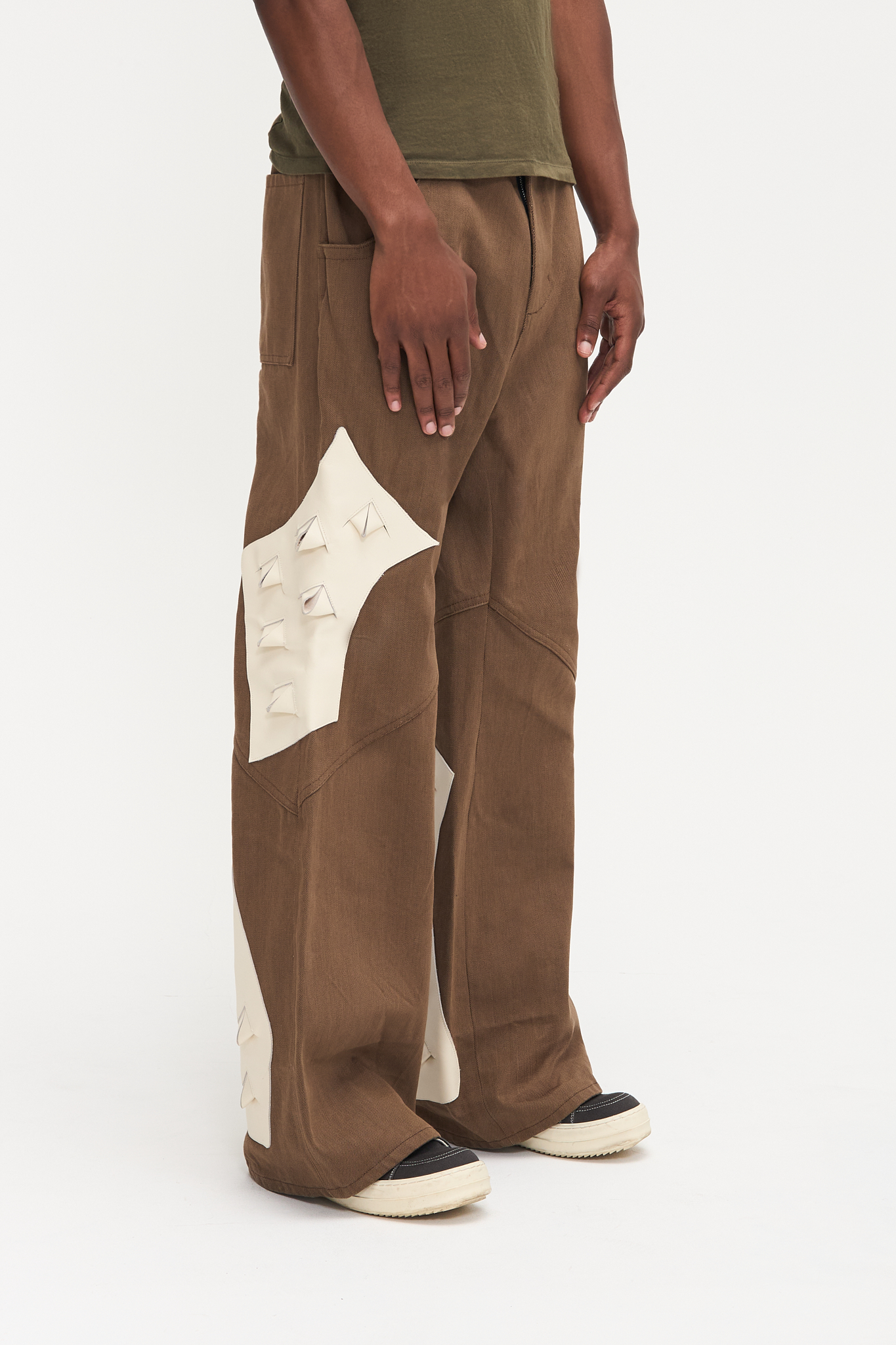 - Flared fit<br />- Deadstock brown denim<br />- White croco 3-D leather patches